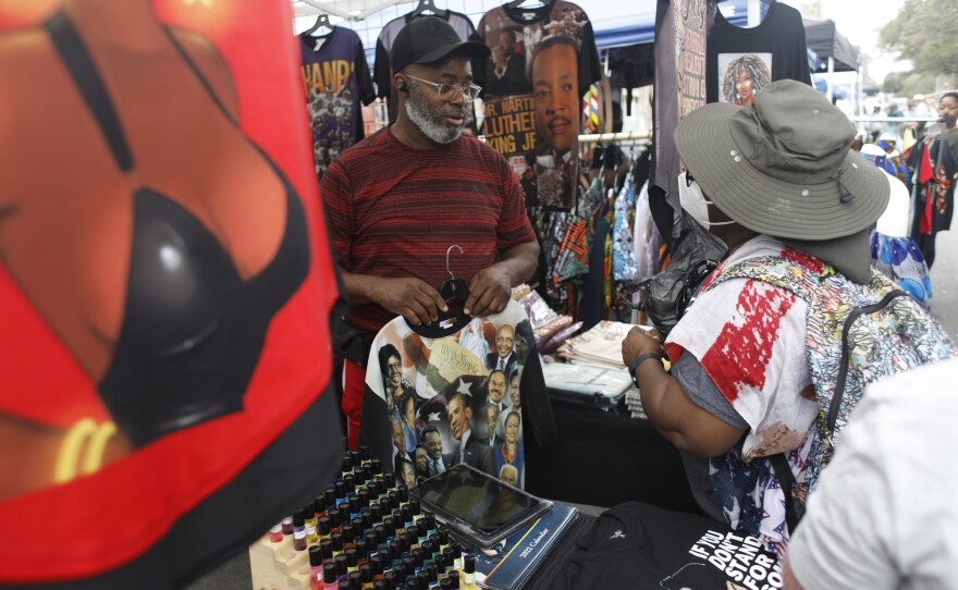 Festival attendees shop for clothing at a booth during the 2022 Publix Tampa Bay Collard Festival in St. Petersburg, Florida, on Saturday, February 19, 2022. Photo by Octavio Jones for WUSF