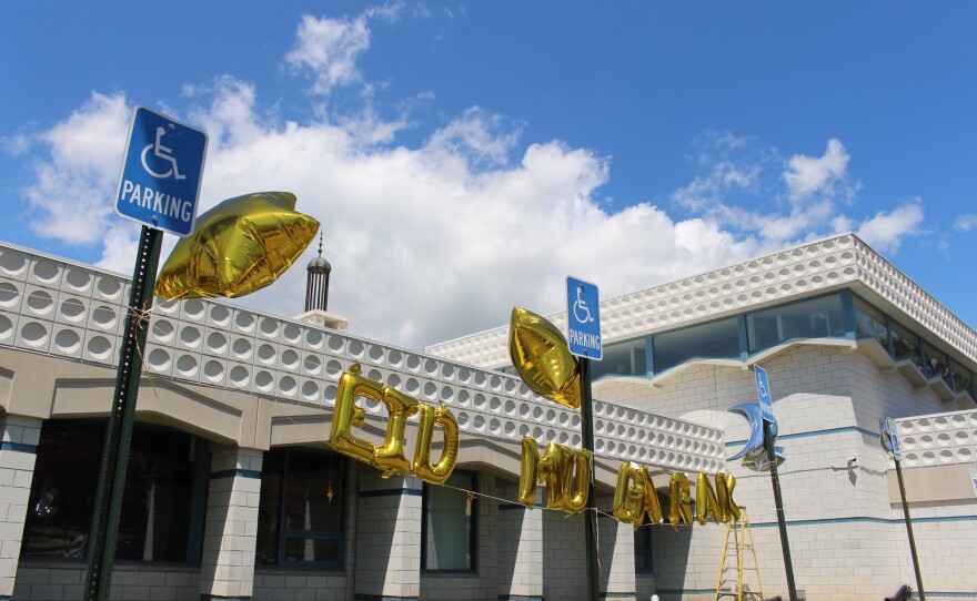 gold balloons spell out "Eid Mubarak" in front of the community center