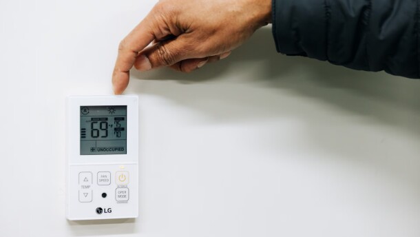 Jonathan Collins, director of mechanical services and engineering at Baltimore City Public Schools, shows a malfunctioning thermostat, which should keep the heat between 70 and 75 degrees, at Arlington Elementary School. (Wesley Lapointe for The Banner)