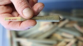 Justin Merkel with some of the his inventory that has yet to be distributed to licensed dispensaries at his cannabis farm in Livingston County. (photo by Max Schulte)