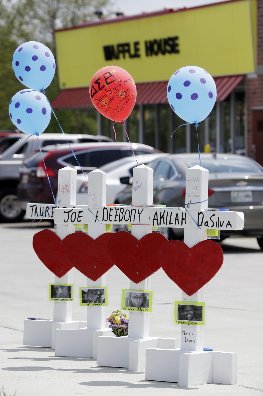 Four wooden crosses stand as a memorial Wednesday to those killed during a shooting at a Waffle House in Nashville, Tenn. The restaurant reopened three days after the attack.