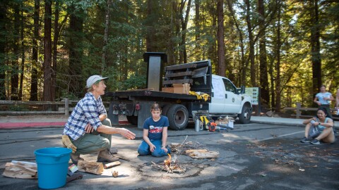 Jane Manning (left) and Daria Celano demonstrate how to extinguish a campfire at the Good Fire Fair in Henry Cowell Redwoods State Park