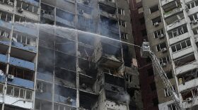 Firefighters work to extinguish a fire in an apartment building after Russian attack in Kyiv, Ukraine, Wednesday, Feb. 7, 2024.