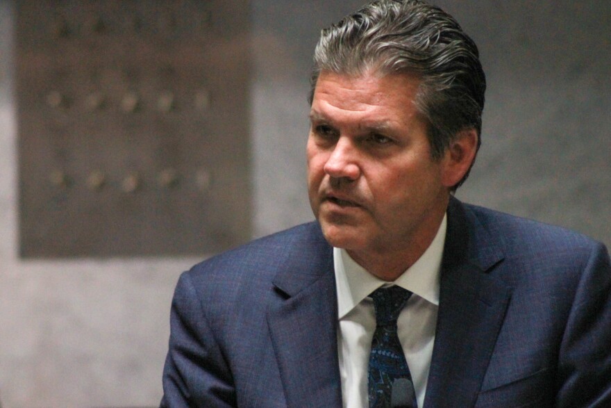 Sen. Ryan Mishler (R-Mishawaka) is pictured looking to the left side of the frame. There is a gray wall behind him, and he is wearing a suit and tie.