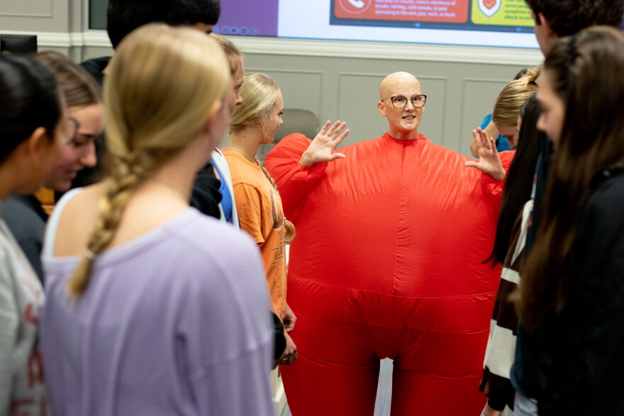 Nichole Jackson, assistant professor of nursing at Oklahoma State University, makes her way up an aisle, representing an red blood cell. About a quarter of OSU nursing students are adult learners or Pell-eligible.