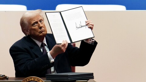 U.S. President Donald Trump holds up an executive order after signing it during an indoor inauguration parade at Capital One Arena on January 20, 2025 in Washington, DC. Donald Trump takes office for his second term as the 47th president of the United States.