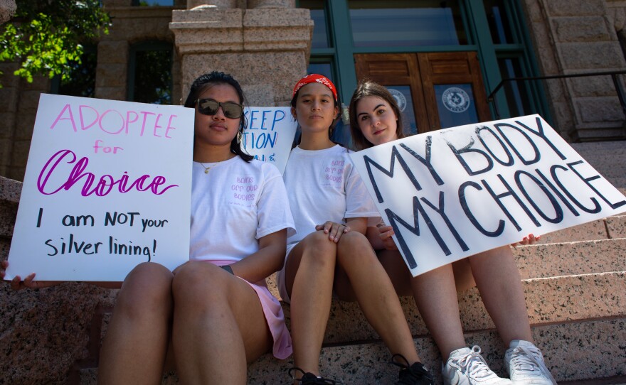 Zoe Seymore, Olivia Castillo, and Maya Perez (left to right) of the Paschal Feminist Club — the organizer of the June 25 pro-choice protest in Fort Worth — sit on the steps of the Tarrant County Courthouse.