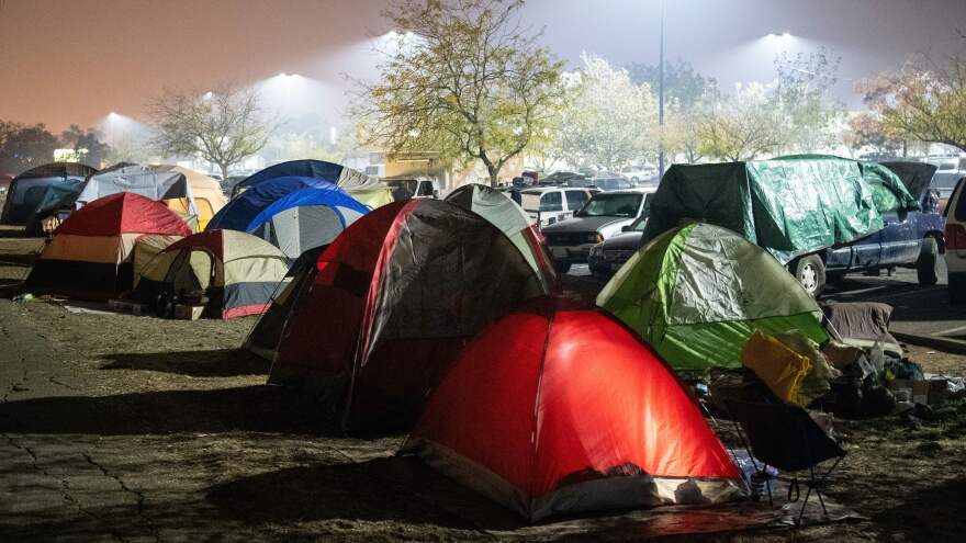 Evacuees retire to their tents for the night in a Walmart parking lot over the weekend in Chico, Calif. The deadliest fire on record in the state has left the living scrambling for answers.