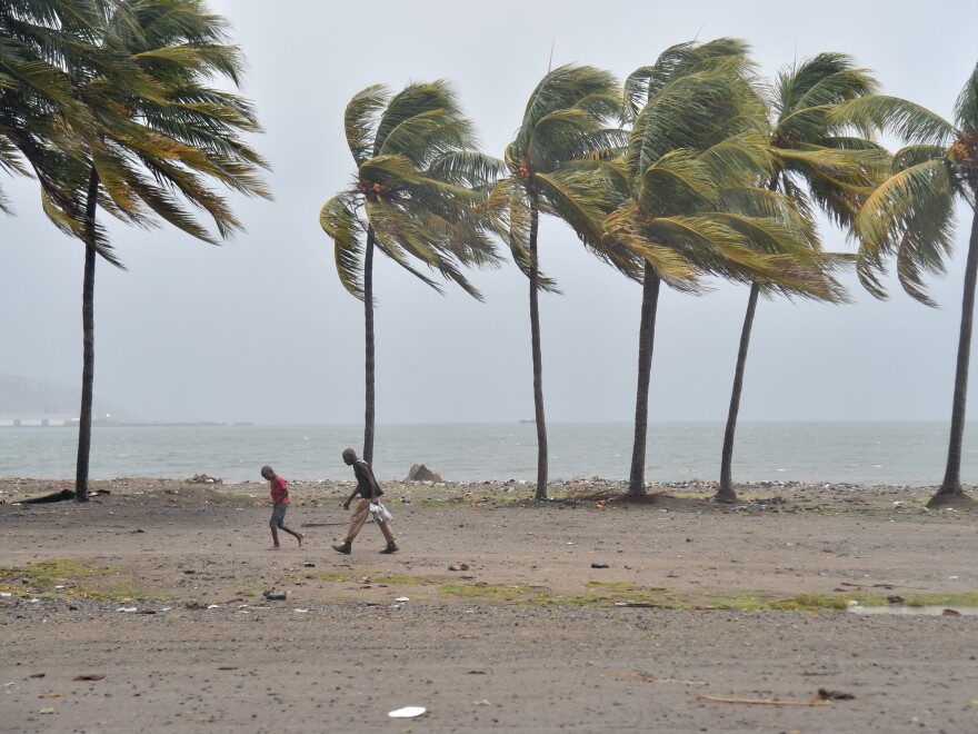 People walk through the wind and rain on a beach in Cap-Haitien on Thursday, as Hurricane Irma approaches.