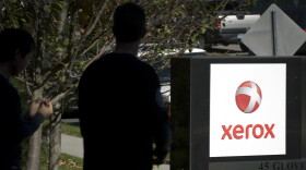 FILE, 2008: Unidentified people pass the Xerox logo at Xerox Corporation headquarters in Norwalk, Conn.