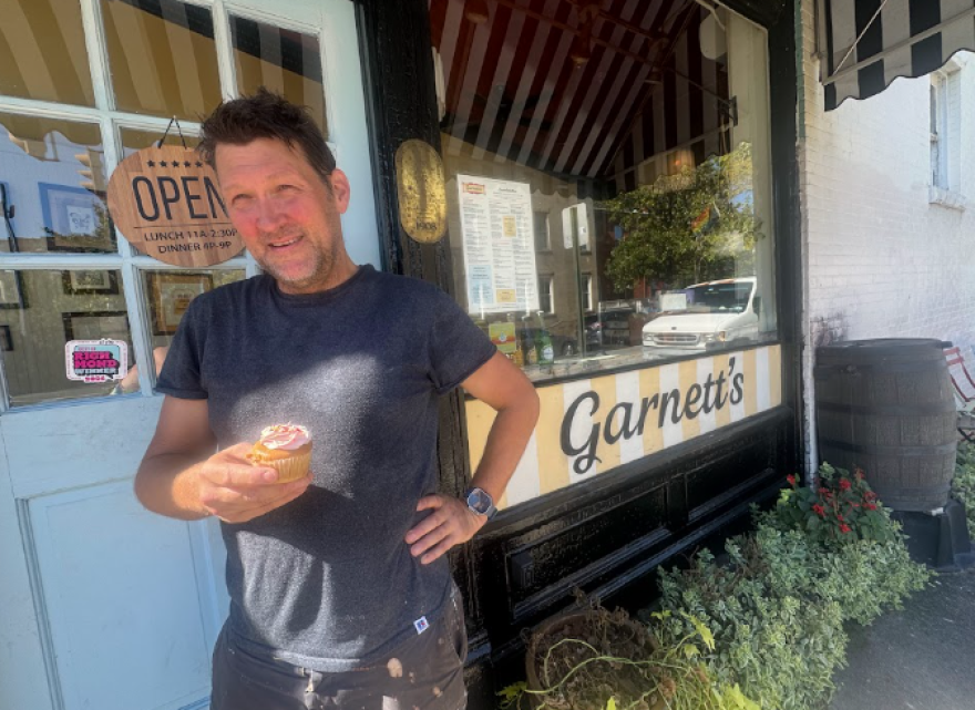 Garnett's manager John Murden holds a cupcake, given to customers on their 17th birthday, celebrated earlier this month. 