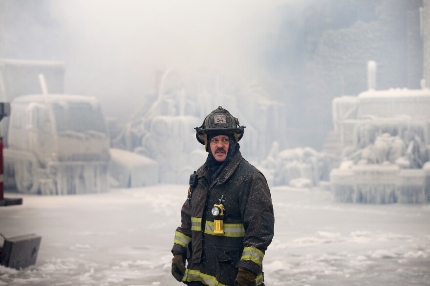 A firefighter helps to extinguish a massive blaze at a vacant warehouse in Chicago.