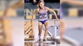 A woman lands in the water after going over some hurdles