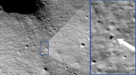 An image of a lunar lander on the surface of the moon. To its right is a zoomed in portion of the image, with a white arrow pointing to the location of the lander.