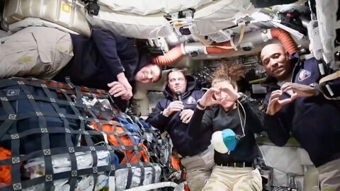 This image from video provided by NASA shows the Artemis II crew Commander Reid Wiseman, second from left, thanking the families of the crew while speaking with NASA Mission Control in a video conference while en route to the moon, Thursday, April 2, 2026, as Canadian astronaut and mission specialist Jeremy Hansen, far left, looks on and mission specialist Christina Koch and pilot Victor Glover, far right, make hearts with their hands. (NASA via AP) CORRECTION: headed to the moon, not in moon's orbit