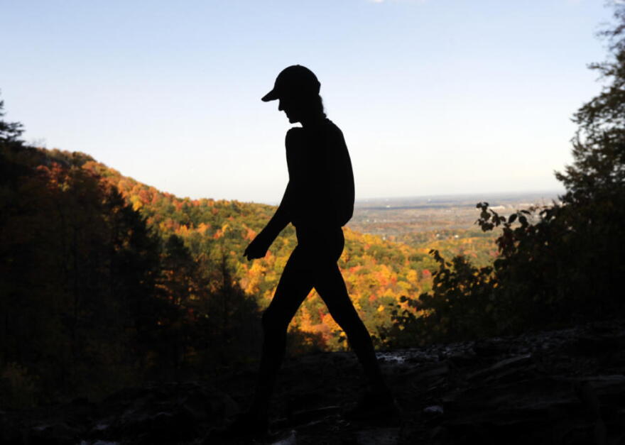 A hiker takes in the fall colors as she makes her way along the Indian Ladder Trail at John Boyd Thacher State Park on Tuesday, Oct. 18, 2016, in Voorheesville, N.Y. (Mike Groll/AP)