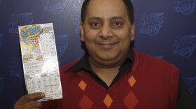 Urooj Khan poses with a winning lottery ticket. He died after winning a $1 million lottery in Chicago. Forensic pathologists at first said Khan died of natural causes, but that ruling was later changed to death by cyanide poisoning.