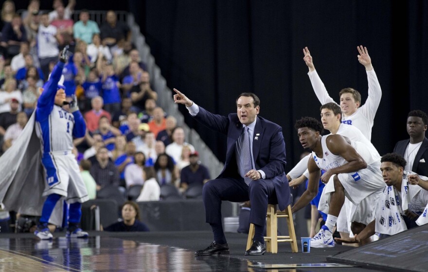 A picture of Coach K with team on sidelines.