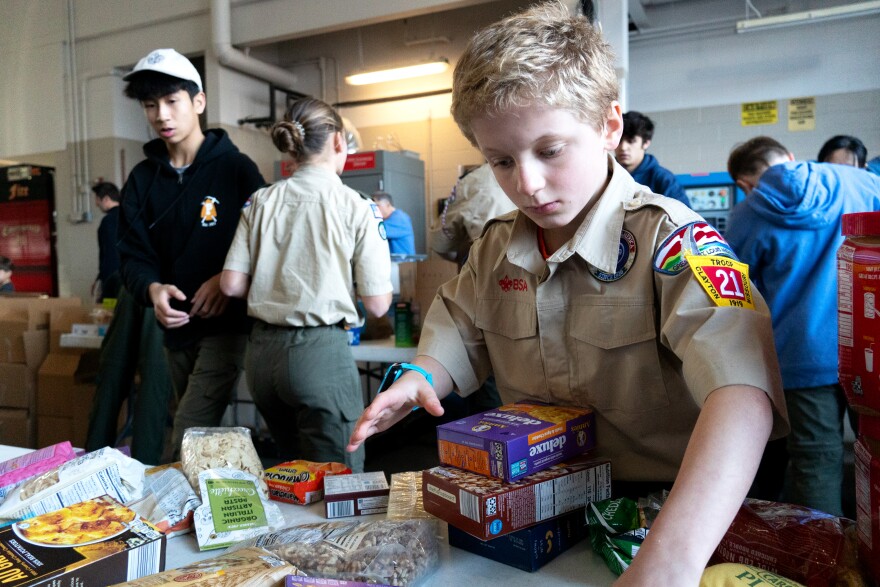 Scout Nate Thompson, 11, of Troop 21 sorts non-perishable food items for the annual Scouting for Food drive. 