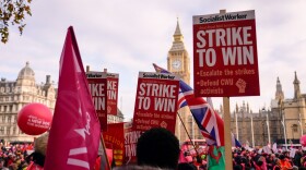Royal Mail workers hold placards and banners as they gather in Parliament Square, to hold a protest over pay and jobs. (Alberto Pezzali/AP)