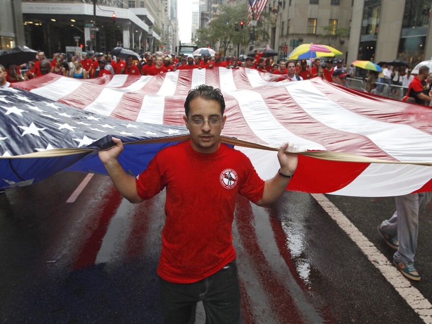 Local 361 iron worker Robert Farula marches up Fifth Ave. carrying an American flag during the Labor Day parade on Sept. 8, 2012 in New York.