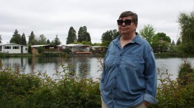 Deann Sweeper, a Marine veteran and Lakewood Vista Mobile Home Park residents, stands in front of the community's pond on May 6, 2026. Sweeper is the chair of the board of residents working to buy the park.