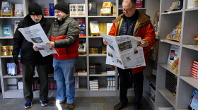 Standing in a local bookstore, Andy Thibault, Editor and Publisher of The Winsted Citizen, left, looks over the paper's first issue with town planner Lance Hansen, center, as Winsted economic development director Ted Shafer, right, looks over his own copy, Friday, Feb. 3, 2023, in Winsted, Conn.