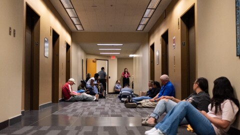 People, including minors, wait outside an immigration courtroom Thursday, July 9, at the Henry M. Jackson Federal Building in Seattle. The courtroom this week began so-called "mega master" hearings that speed up immigration hearings for youth pursuing legal status in the U.S.