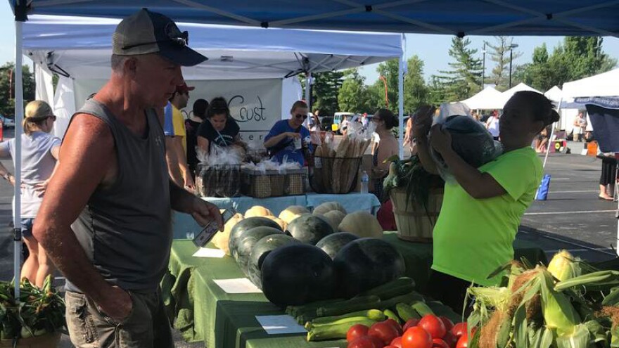 Samantha Wilmot bags a watermelon for a customer at the Columbus Farmers Market in Barthlomew County. Wilmot is one of many farmers market vendors who accepts Supplemental Nutrition Assistance Program benefits.
