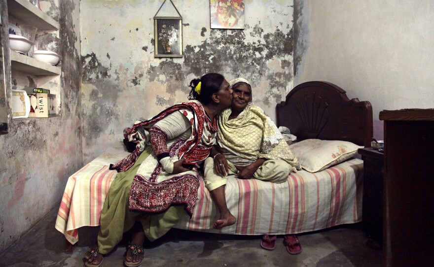 Ashi kisses her mother in the small basement apartment they share in Lahore.