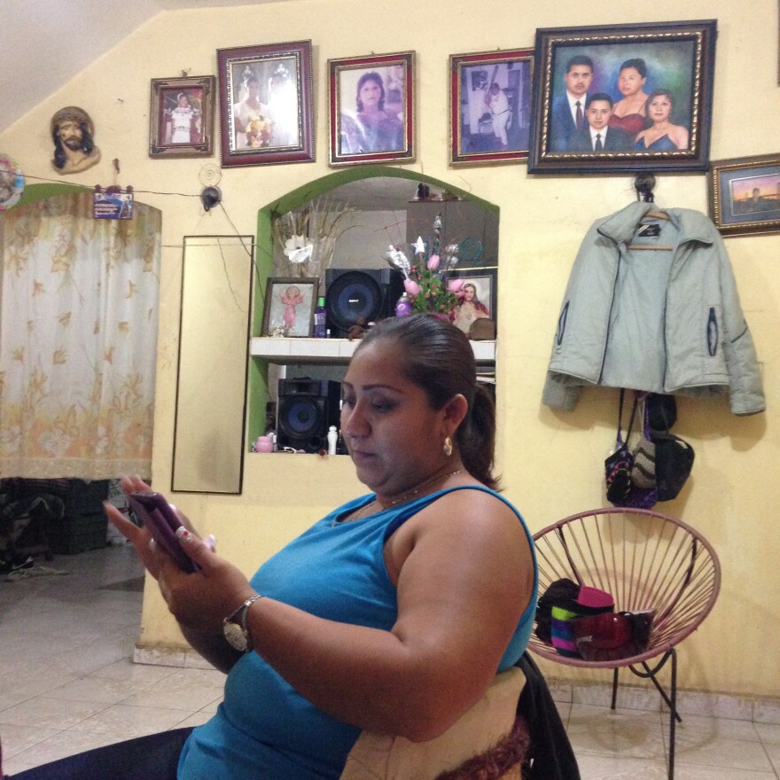 Asunción Diaz looks through her smartphone in Oxkutzcab, Mexico. She uses social media to stay in touch with her father and two brothers who immigrated to the United States.