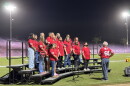 Community members sing the national anthem during the Kerman High School football homecoming game.