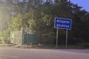 A blue Alligator Alcatraz sign, signifying private property, stands at the entrance to the gate detention center property.