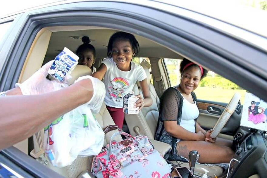  A family gets three breakfasts at Dillard High School in Fort Lauderdale in March 2020. Drive-thru meal pickups, food trucks and delivery via school bus are some of the ways school districts and nonprofits have helped get food to families during the pandemic.