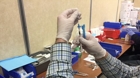 A medical provider preparing a COVID-19 vaccine