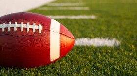 A football in front of yard lines