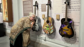 A museum guest listens to a guitar specially tuned for the Goo Goo Dolls' hit "Name" during an exclusive member-only event for the exhibit "Long Way Home: 40 Years of the Goo Goo Dolls" at the Buffalo History Museum on September 16, 2026.