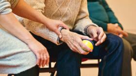 an elderly person being comforted by another person