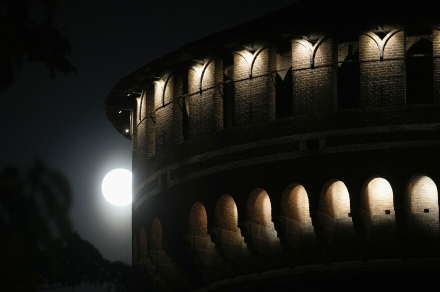 Milan, Italy: The full moon rises over the Sforzesco Castle.