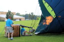 Balloon meister Austin Hopp, crouching, fires up large propane tanks to upright his hot air balloon. He's among 19 pilots planning to fly over the City of Lincoln this weekend as part of its signature Balloons Over 66 festival.