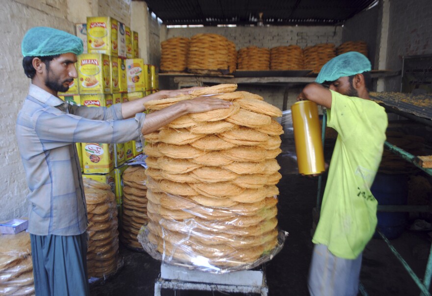 <strong>Hyderabad, Pakistan:</strong> Pakistani men makes traditional sweets at a market to be displayed for sale ahead of Ramadan.