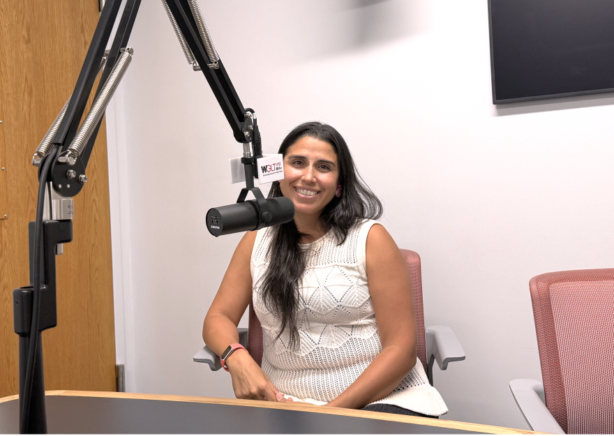 Dr. Javiera Monardez Popelka sitting behind a microphone in the WGLT studios.