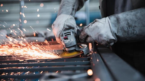 A person works with a manufacturing tool.