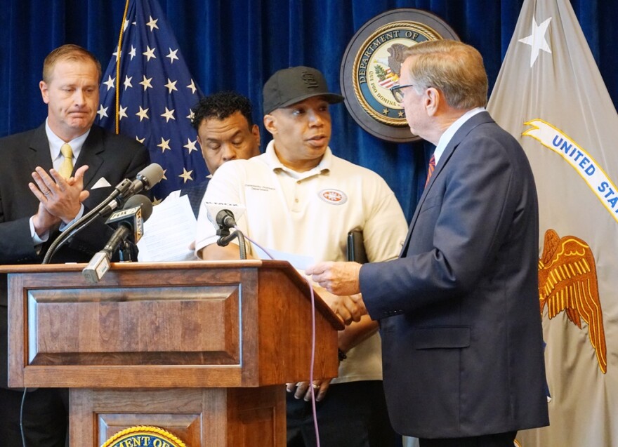 James Clark, the vice president of community outreach at Better Family Life, accepts a $200,000 check from Ed Dowd, the president of the St. Louis Crime Commission, on Monday. Clark will use the money to hire more outreach workers to help reduce violence.