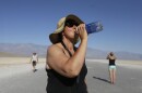 Maria Wieser, of Italy, takes a drink of water while sightseeing in Death Vally National Park, Friday, June 28, 2013 in Badwater, Calif. Excessive heat warnings will continue for much of the Desert Southwest as building high pressure triggers major warming in eastern California, Nevada, and Arizona.