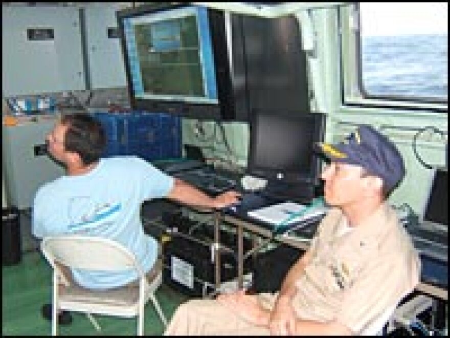 As the ship drags a magnetometer over the search area, the scientists keep an eye on computer screens to see what it finds.