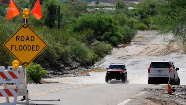 Vehicles navigate on a road after torrential rains moved through the Phoenix metro area, Tuesday, Sept. 29, 2026, in Anthem, Ariz.