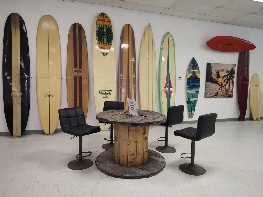At the Surfing Florida Museum, visitors can sit at a cable-spool table and admire the historic boards.