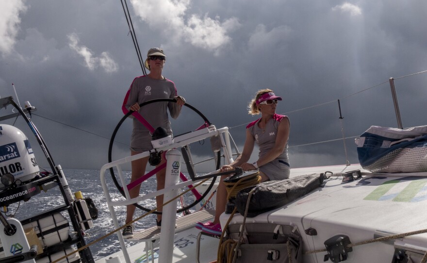 Leg 2 onboard Team SCA, in November 2014. Elodie Mettraux helms and Sam Davies trims main as a squal passes behind the boat.