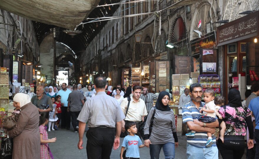 Syrians walk at the al-Bzoureya market in Old Damascus on Thursday.